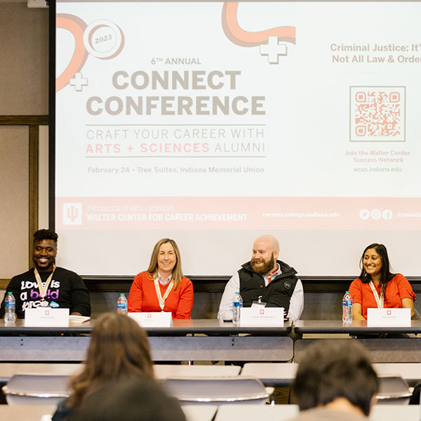 A group of people present at a conference, seated at a table.