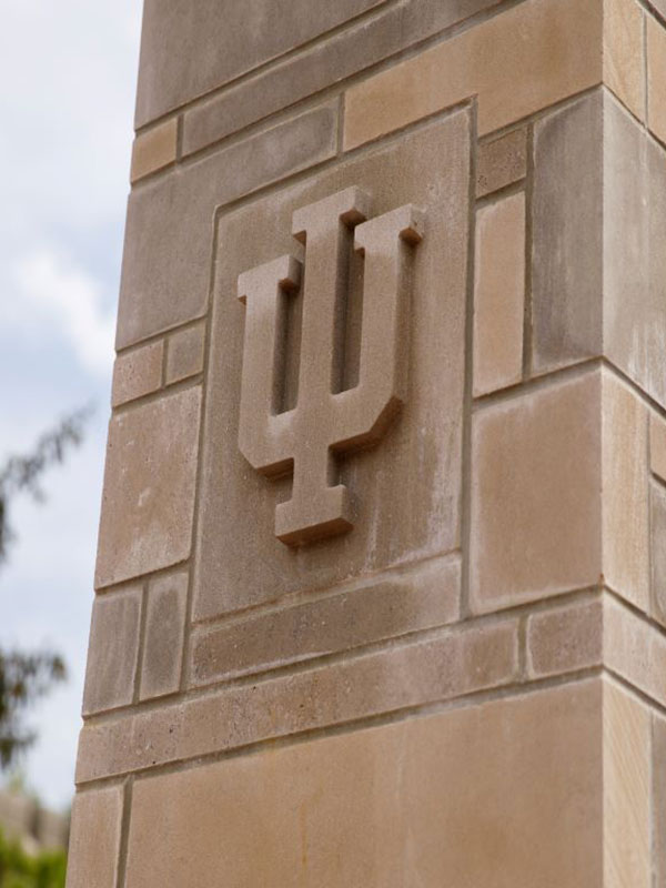 A photo of a limestone pillar, with the IU trident embossed in stone.